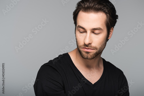 good-looking man in black t-shirt looking away isolated on gray.