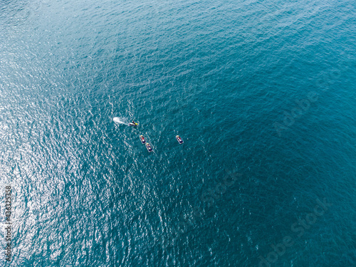 Surfers and paddle boarders in a turquoise sea aerial uk cornwall 