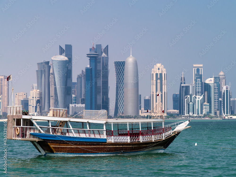 Old dhow against city skyline 
