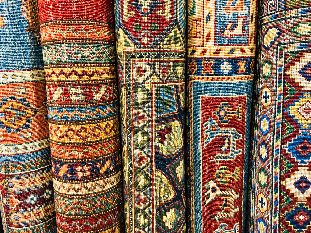 Handwoven rugs rolled up and lined up in a shop Handwoven rugs rolled up and lined up in a shop