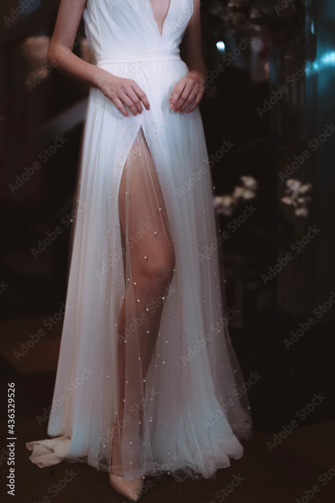 Fototapeta premium Cropped figure of model dressed in white long wedding dress. fashion details on backstage Fashion Week