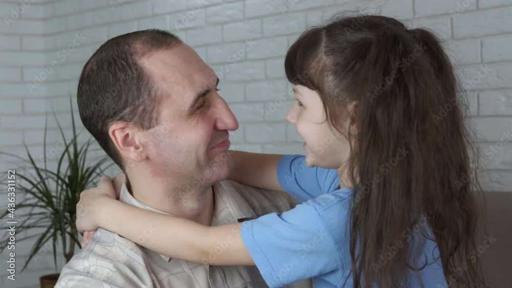 Warm embracing with father. A smiling dad warmly embrace her little girl in the room. Warm embracing with father. A smiling dad warmly embrace her little girl in the room.