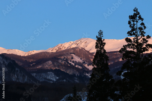 白馬栂池から見える夕日が差し込む雪山