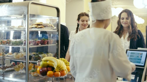 Group of students stand at full lunch service station.