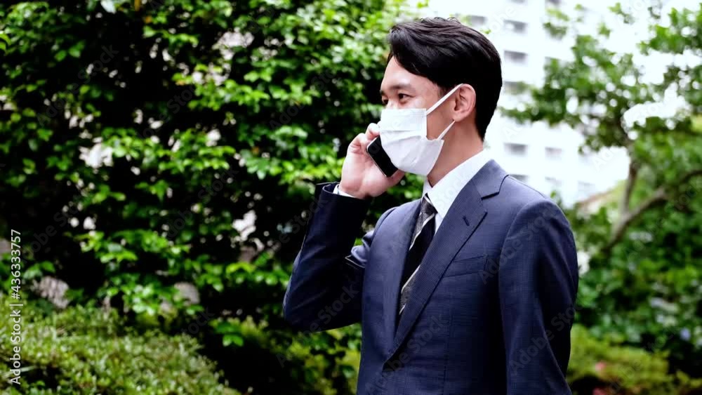 マスクをして電話を切るビジネスマン