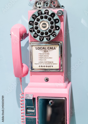 old retro pink wall phone on blue background