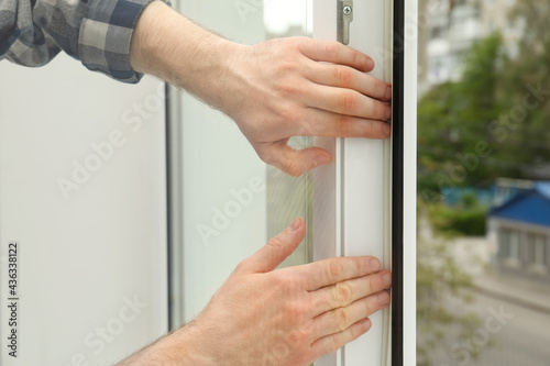 Canvastavla Worker putting rubber draught strip onto window indoors, closeup