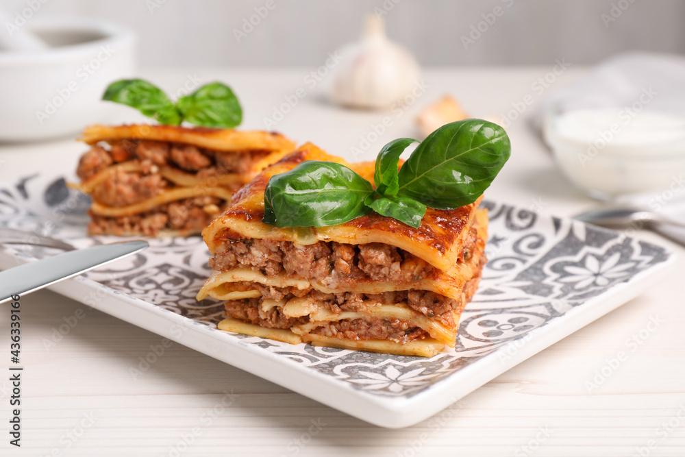 Delicious lasagna served on white table, closeup Delicious lasagna served on white table, closeup