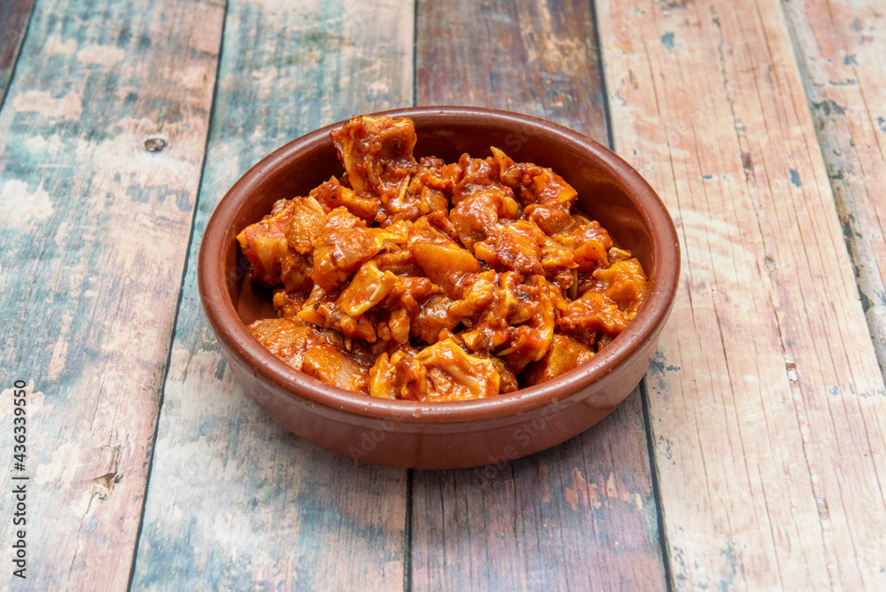 Fototapeta premium Spanish tapa of marinated pork ear inside clay pan