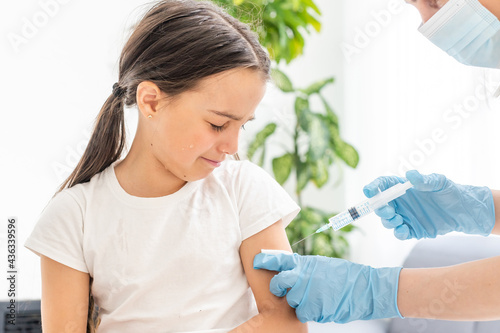 nurse giving vaccination injection to little girl patient