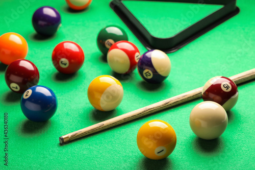 Foto Many colorful billiard balls and cue on green table