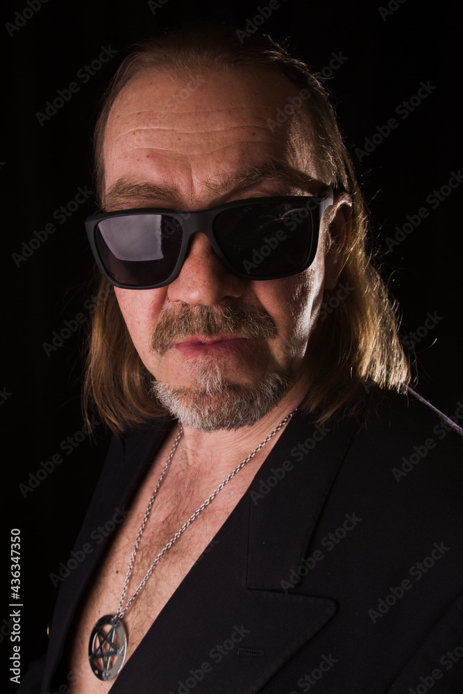 Obraz premium Portrait of a man in a jacket and sunglasses, rock.