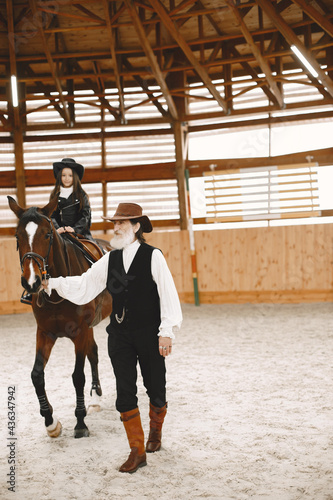A little child riding a horse with an instructor