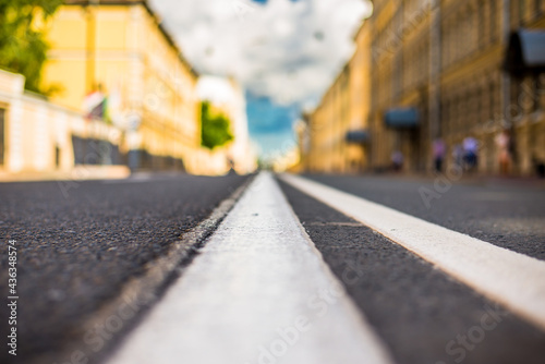 Clear day in the big city, empty city street. View of the road at the level of the dividing line