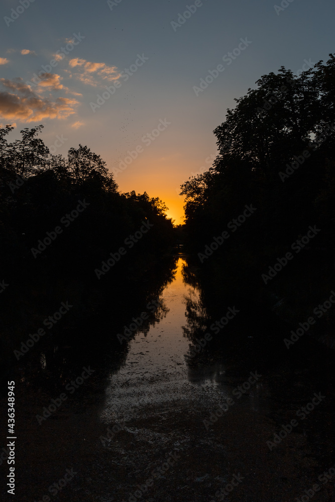 Beauty sunset over small river between high trees Beauty sunset over small river between high trees