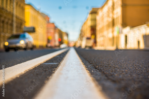 Clear day in the big city, car traveling on an empty city street. View of the road at the level of the dividing line