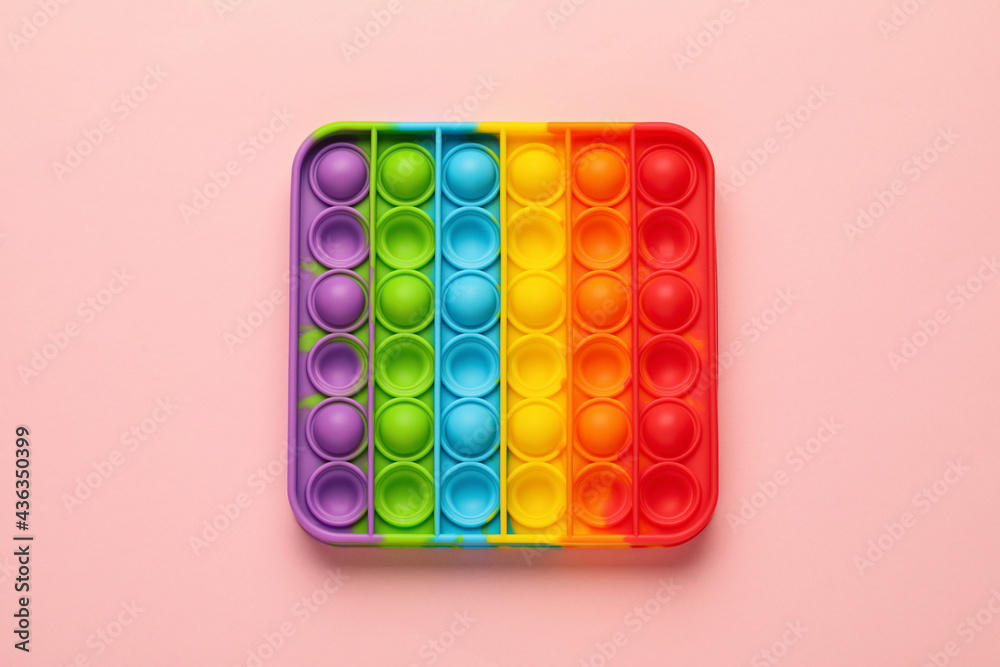 Rainbow pop it fidget toy on pink background, top view Rainbow pop it fidget toy on pink background, top view