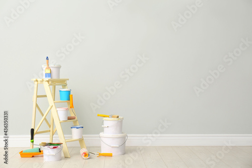 Fototapeta Naklejka Na Ścianę i Meble -  Decorator's kit of tools and paints near light wall indoors. Space for text