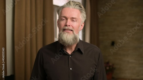gray-haired bearded adult man listens attentively to something, communicating via video communication, view from the person of the interlocutor