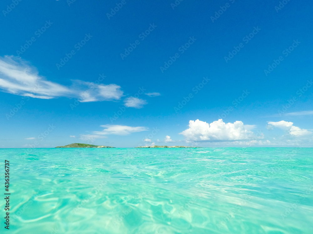 Clear blue sky with clouds and turquoise blue ocean water in the Caribbean Clear blue sky with clouds and turquoise blue ocean water in the Caribbean