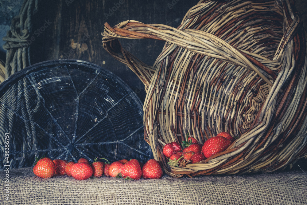 Strawberries in a basket on a wooden background