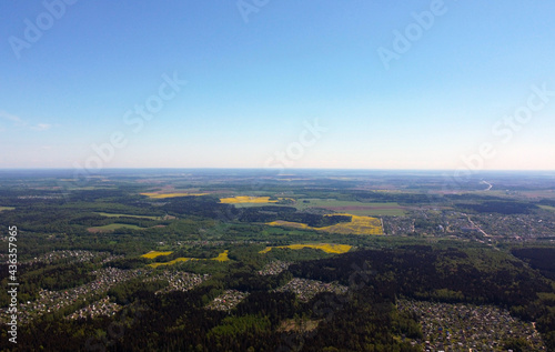 Aerial view from the drone on a landscape with fields, forests and suburbs. Summer panorama from the sky