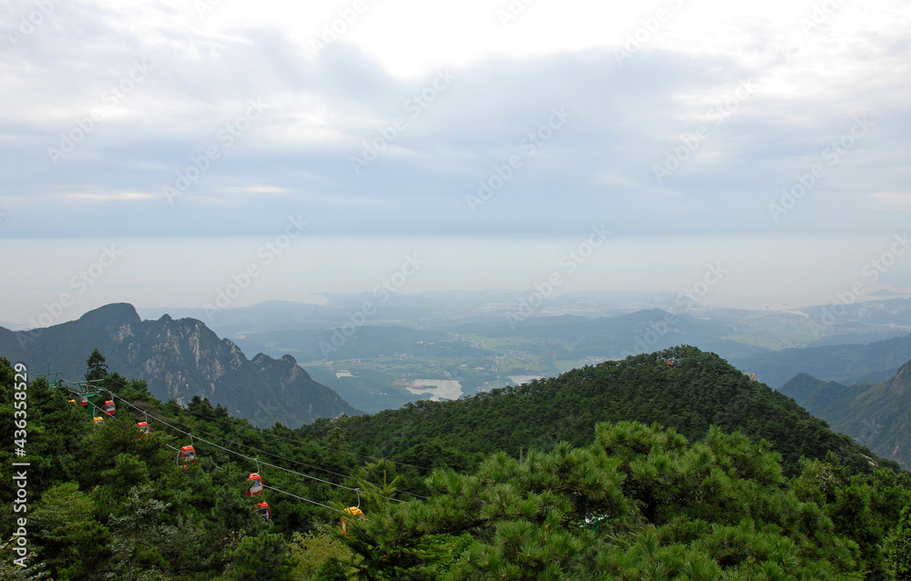 Lushan Mountain in Jiangxi Province, China. Cable cars ascending Mount Lu with views of the mountain, forest and peaks. Lushan National Park is a tourist attraction and UNESCO World Heritage Site.