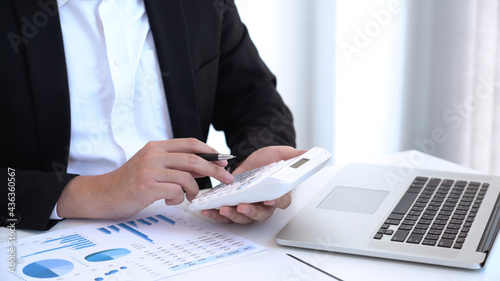 Billede på lærred Business concept a male accountant using a calculator counting company’s profits and losses, preparing financial reports for business