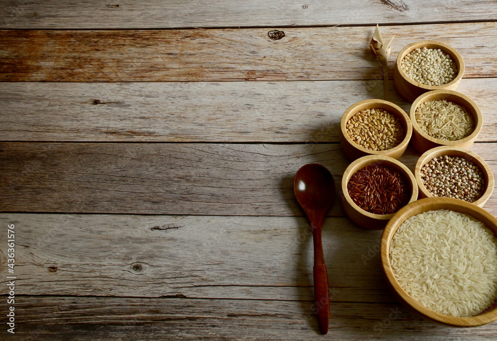 Brown Glutinious Rice, Red Jasmine Rice, Oat Rice, Barley, Millet Rice, Brown Wheat in wooden bowl and wooden spoon on wooden table background. Brown Glutinious Rice, Red Jasmine Rice, Oat Rice, Barley, Millet Rice, Brown Wheat in wooden bowl and wooden spoon on wooden table background.