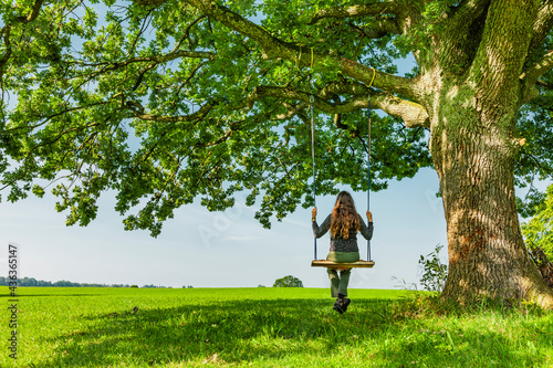 Frau auf einer Schaukel an einem Eichenbaum