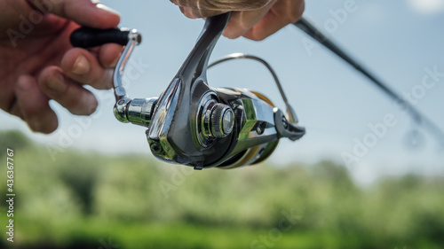 Fishing rod wheel closeup, man fishing