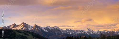 A beautiful panorama of the Bielskie Tatras. White mountain peaks in the distance Beautiful colors of the sky. View at sunset. Jurgow, Poland