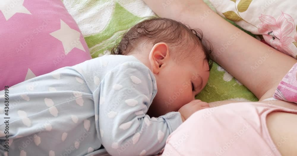 Woman breastfeeding newborn baby. Baby eating mother's milk. Concept of lactation infant Woman breastfeeding newborn baby. Baby eating mother's milk. Concept of lactation infant