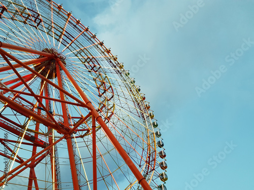 Red Ferris wheel against the background of the evening sky