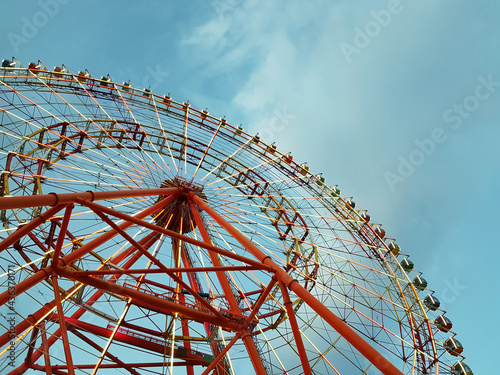 Red Ferris wheel against the background of the evening sky