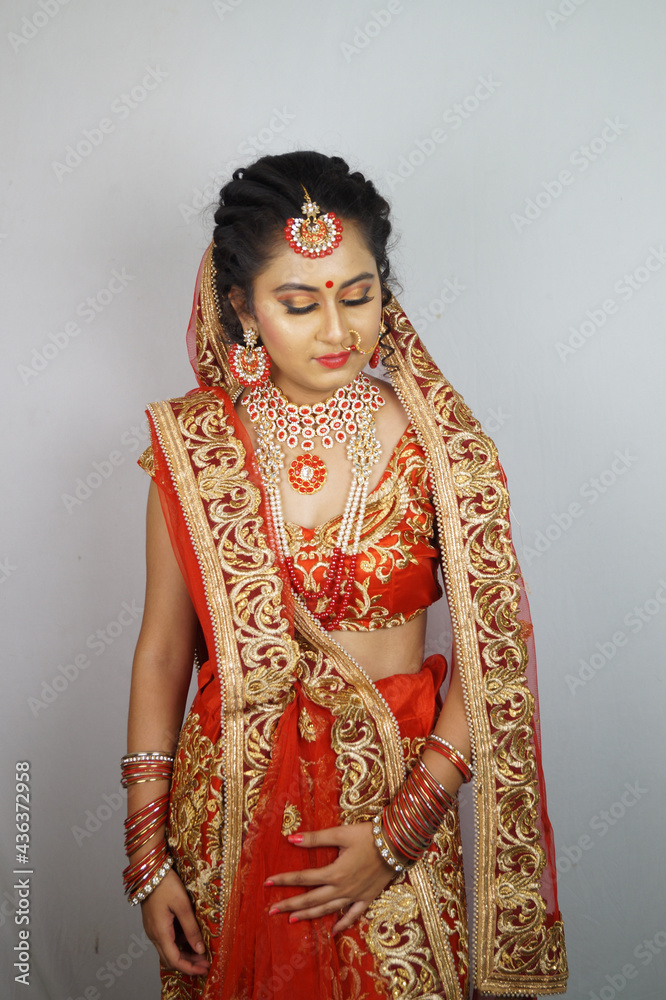 Beautiful Indian woman in a traditional red sari dress posing against a ...