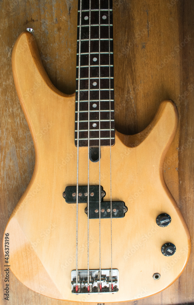 Fototapeta premium instrumento Bajo Eléctrico color madera con fondo de madera 