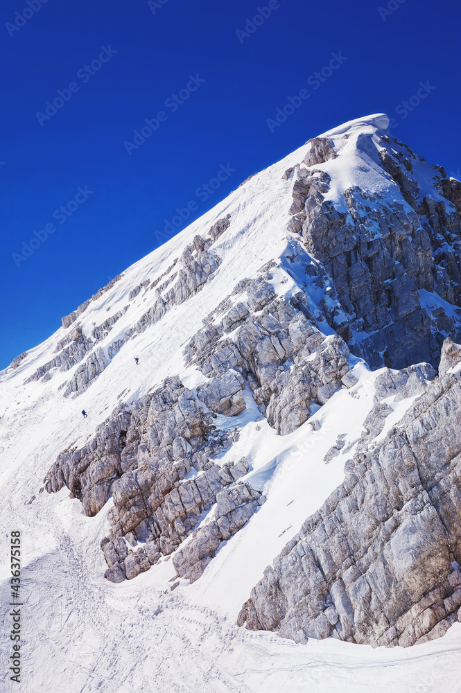 little skalpinist climbs a snowy 
mountainside slovenian alps Mala Mojstrovka