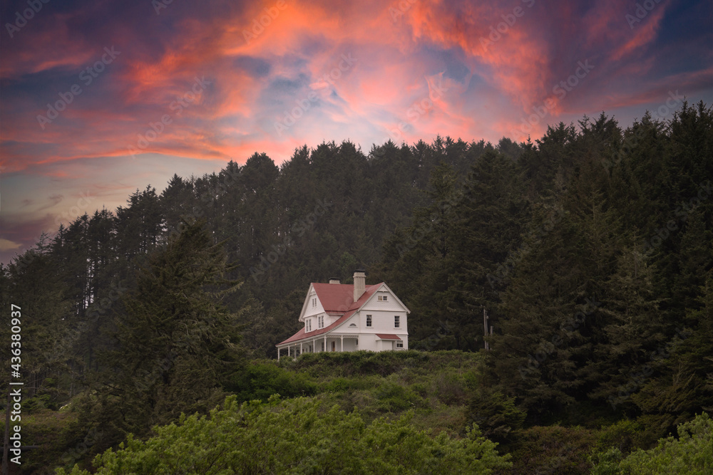 Fototapeta premium Historic lighthouse keepers house at sunsetat Heceta Head near Cape Perpetua on the Oregon coast near Floresnce.