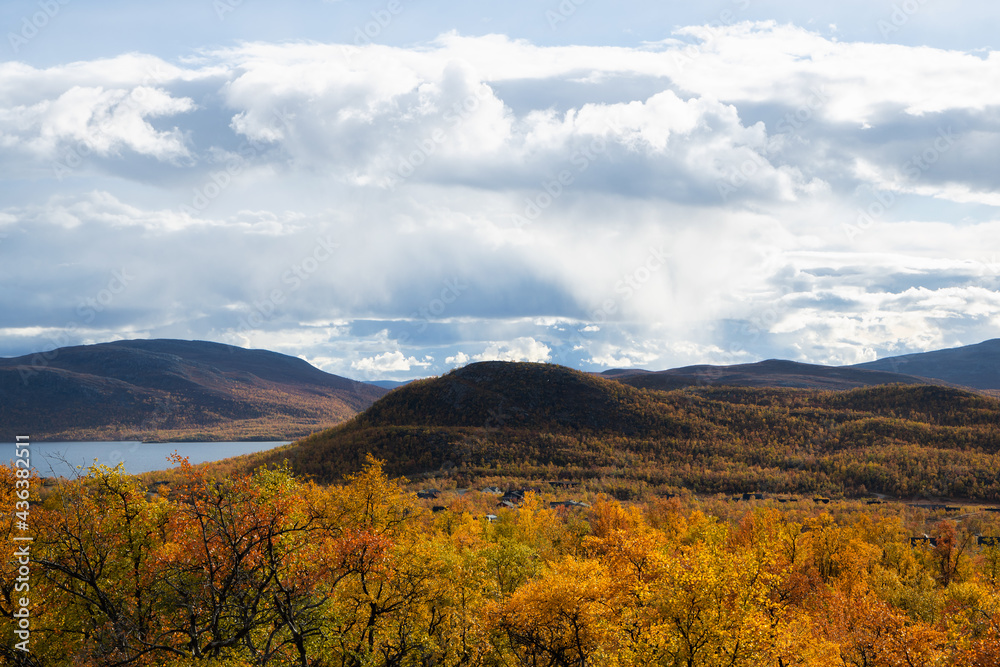 Amazing view of the Lake among colorful fall forest, Lapland. Scenic wooded mountains. Kilpisjarvi.