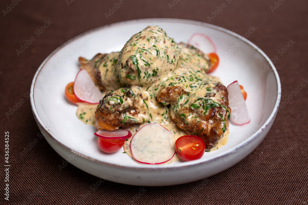 chicken dish with cream sauce with radish and tomato. dish from the chef chicken dish with cream sauce with radish and tomato. dish from the chef