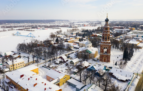 Scenic view from drone of temple complex of Cathedral of Archangel Michael and Church of Jerusalem Icon of Mother of God with Bronnitsy cityscape on background in winter, Russia..