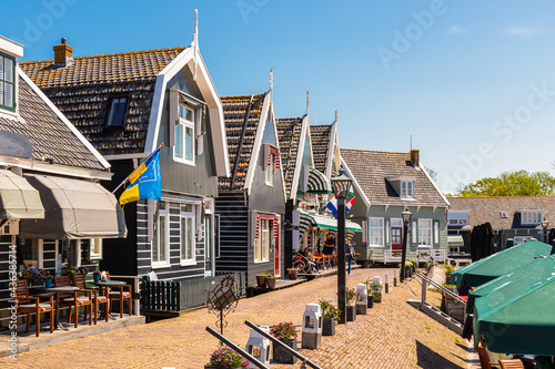 Catering establishments and souvenir shops in traditional wooden houses at the small harbor in the picturesque fishing village of Marken. photo