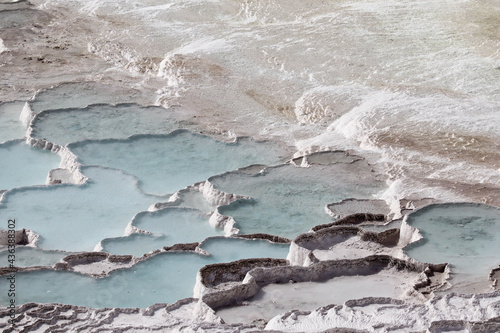 scenic view - azure water from thermal hot springs in white limestone pools travertine in Pamukkale, Turkey