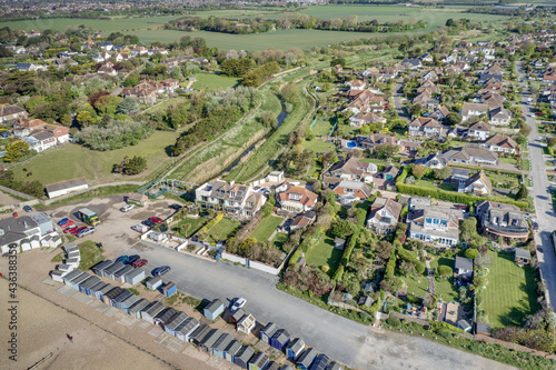 Ferring seafront on the English Channel with the Aerial view of Ferring Rife running next to the village of Ferring in West Sussex and towards the Beach Huts and coastline.