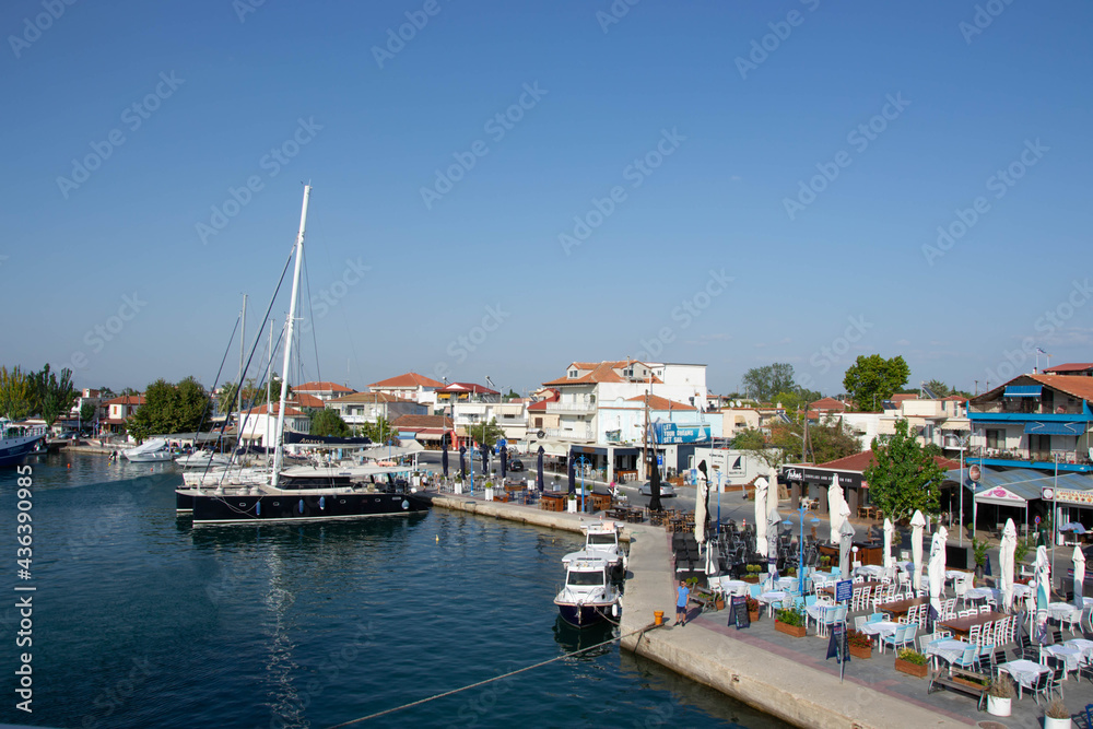 Boats at the port of village of Keramoti, Greece. Thasos island harbor, beautiful blue water and sky, tavernas, café and restaurants, travel destination