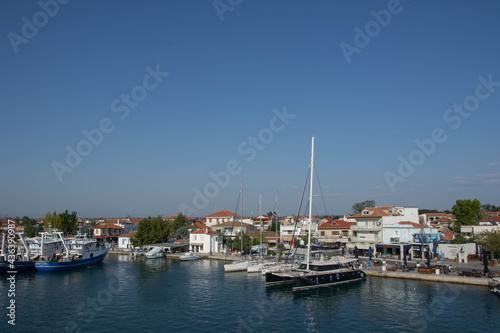 Boats at the port of village of Keramoti, Greece. Thasos island harbor, beautiful blue water and sky, tavernas, café and restaurants, travel destination