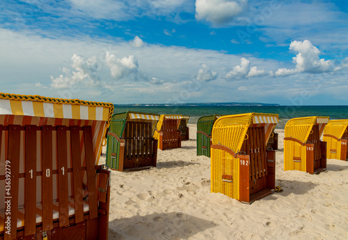Gelbe und grüne Strandkörbe am Meer, auf dem Strand mit Wolken im Sommer in der Sonne an der Ostsee nach Corona, vor der Eröffnung © DK_DD