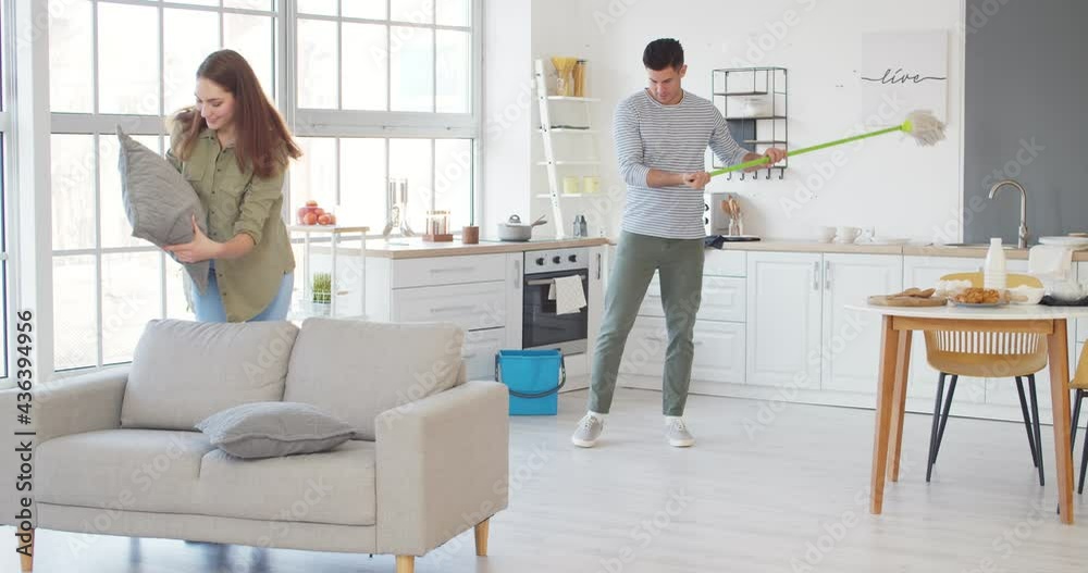Young couple cleaning their house together Young couple cleaning their house together