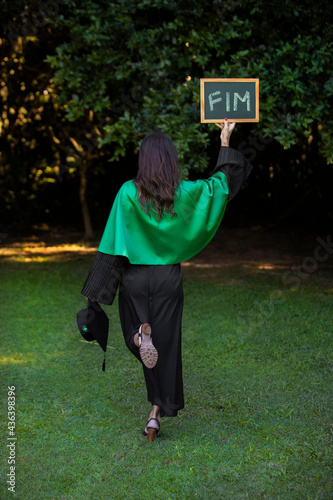 graduate holding a sign written end